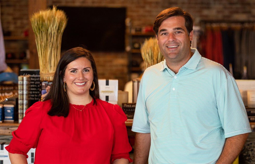 TJ Callaway and Virginia Johnston of Onward Reserve stand beside each other in their Buckhead store. They are smiling at the camera.