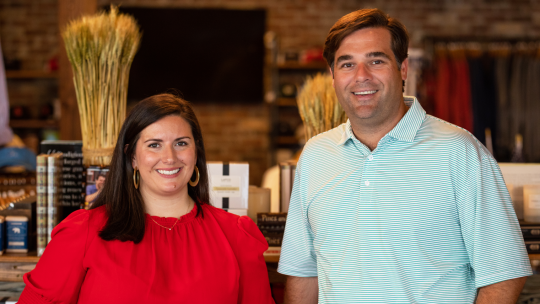 TJ Callaway and Virginia Johnston of Onward Reserve stand beside each other in their Buckhead store. They are smiling at the camera.